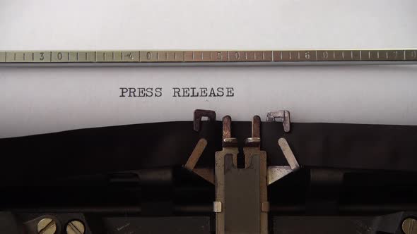 Typing phrase Press Release on retro typewriter. Close up.