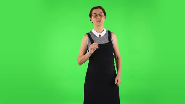 Funny Girl in Round Glasses Is Waving Hand and Showing Gesture Come Here. Green Screen