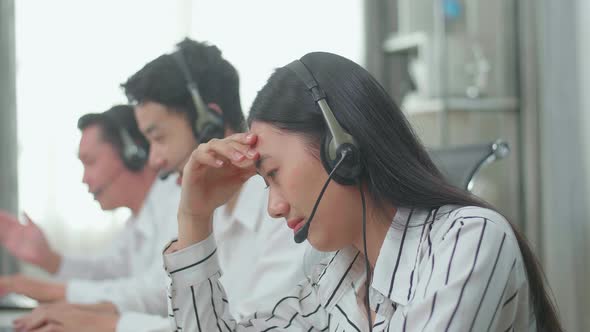 A Woman Of Three Asian Call Centre Agents Headache While Her Colleagues Are Speaking to Customer