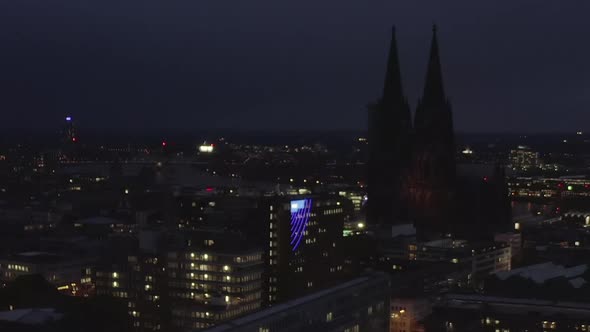 AERIAL: Wide Shot of Cologne Germany From the Air with Majestic Cathedral at Night 