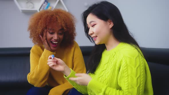 Happy Two Young Women Best Friends Looking at Positive Pregnancy Test