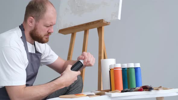 A Professional Artist Mixes a Palette of Paints for Painting