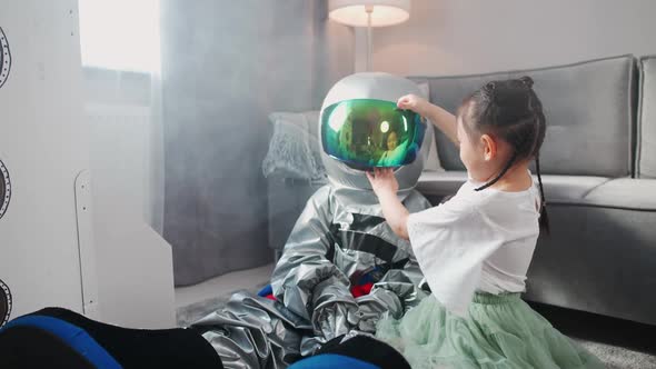 Asian Kids Play in the Living Room at Home a Boy in an Astronaut Costume Sitting on the Floor with