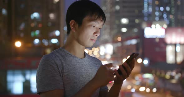 Asian Man Use of Mobile Phone in City at Night