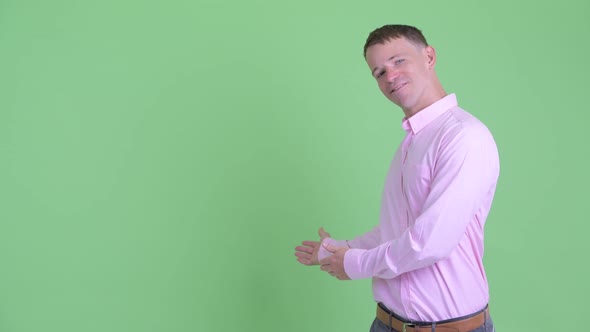 Portrait of Happy Businessman Showing To Back and Giving Thumbs Up