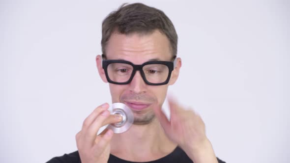 Studio Shot of Happy Nerd Man Playing with Fidget Spinner