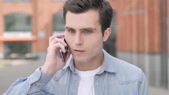 Angry Young Man Talking on Phone
