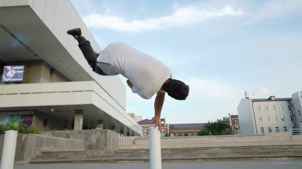 Athletic Man Jump Somersaults in an Urban Setting Backdrop Beautiful Building