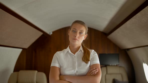 Confident Businesswoman Inside of Private Jet Standing, Seriously Looking at Camera