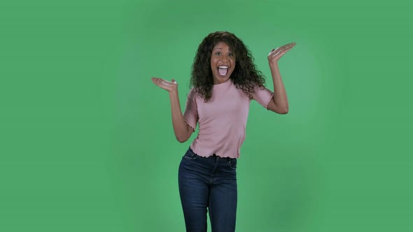 Portrait of Beautiful African American Young Woman Looking at Camera and Performs a Dance of Joy and