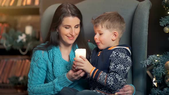 A Mother and a Son Having Fun in Front of the Firtree with Candle