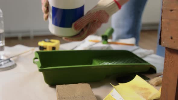 Hands in Gloves Pouring Grey Color Paint to Tray