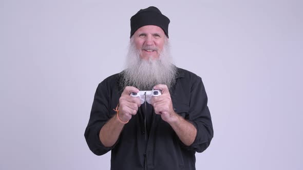 Happy Mature Bearded Hipster Man Playing Games and Winning