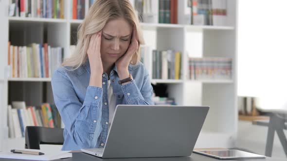 Stressed Young Woman with Headache Working on Laptop