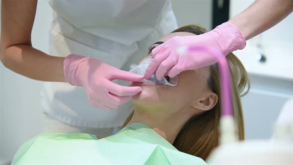 Orthodontist Puts Oral Ring On Patient's Mouth.