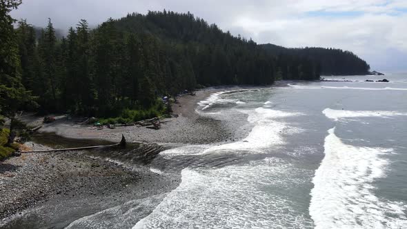 Aerial footage in 4k of Sombrio beach on a cloudy day during spring of 2021. Big waves crashing on t