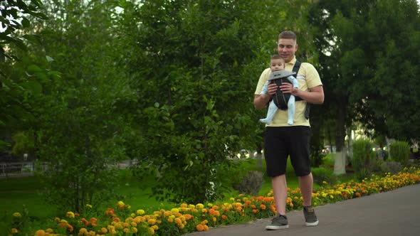 A Young Man Walks Along the Alley in the Park