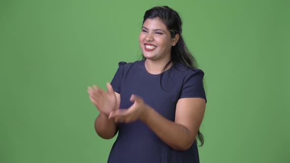 Young Overweight Beautiful Indian Businesswoman Against Green Background