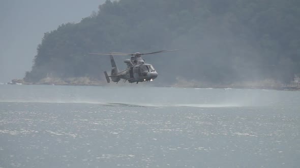  Military, rescue helicopter hovering low over the water, during a rescue mission