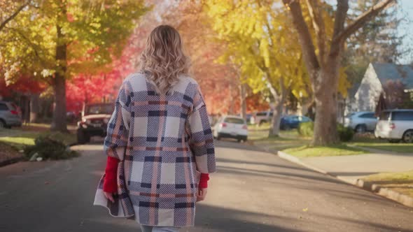 Back View Woman Enjoying Walk By Small Town on Sunny Autumn Day  Footage USA