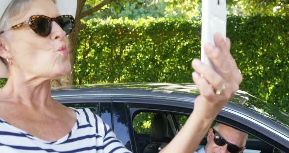 Senior man looking at woman while taking selfie