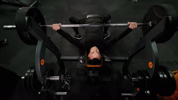 Top View of Fit Man Lifting Barbells in Gym