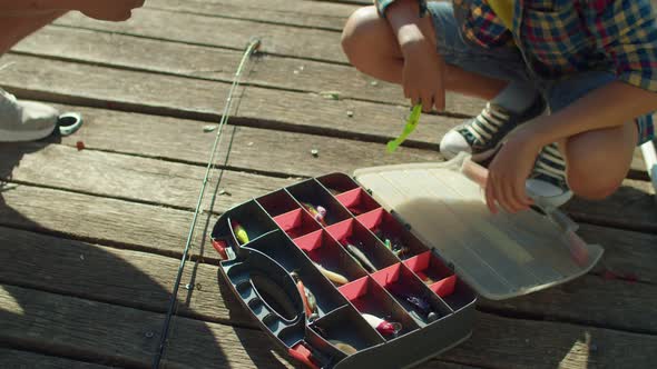 School Age Fisherman Learning Fishing Tackles and Lures During Fishing