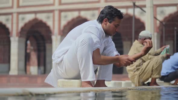 Indian man cleaning himself before going for Ramadan prayer