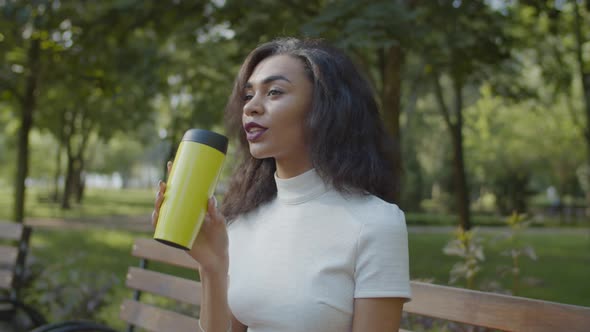 Pretty Black Female Drinking Coffee Outdoors