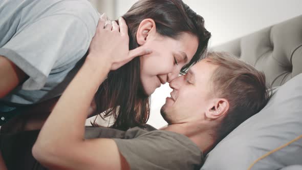 Close Up Side View of Sexy Young Couple Kissing in Bed