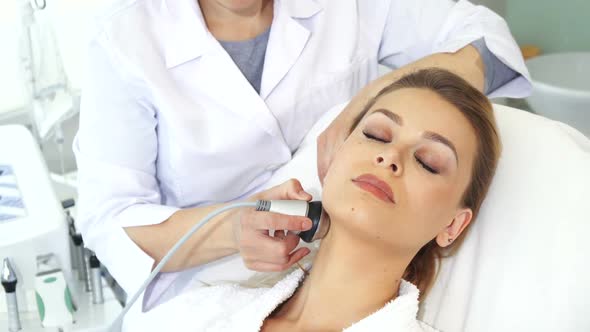 Cosmetologist Makes Facial Massage with Special Equipment