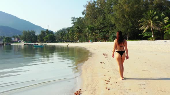 Female models relaxing on tranquil island beach holiday by blue sea with white sand background of Ko