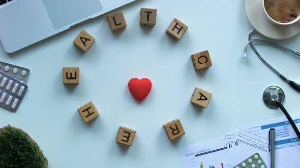 Healthcare on Wooden Cubes Moving Around Toy Heart on Doctors Table, Stop Motion