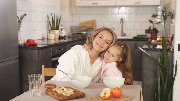 Portrait of a Happy Family of Two a Little Girl Hugging Her Beloved Mother They Are Sitting at the