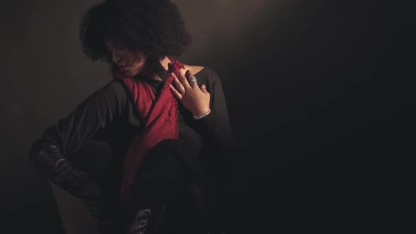 Woman in Red Scarf Sits in Chair