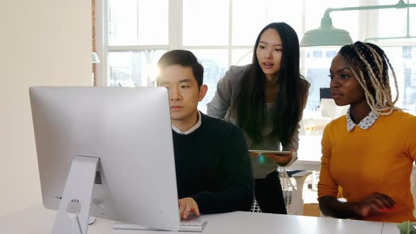 Business executives having discussion over personal computer