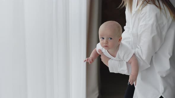 Close Up of Affectionate Mother Playing with Newborn Son