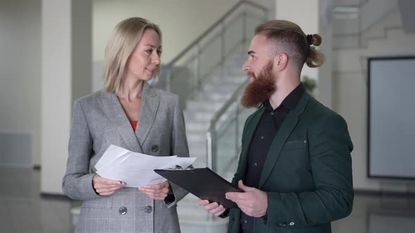 Medium Shot Confident Caucasian Man and Woman Talking Turning Looking at Camera Smiling Standing in