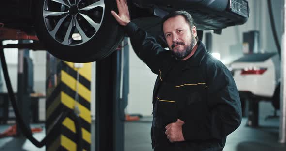 Happy and Smiling Mature Mechanic Man in a Car