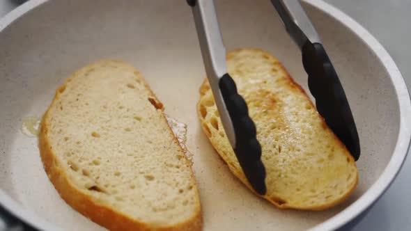Anonymous person frying bread slices in pan