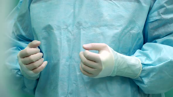 a Nurse Helps the Surgeon Put on Gloves