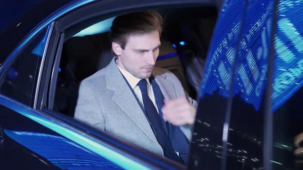 Handheld Businessman Sitting in a Moving Car and Using Laptop Man Top Manager in a Suit is Sitting