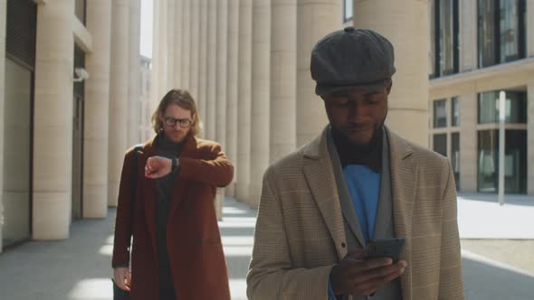 Black Businessman Walking on Street and Using Smartphone