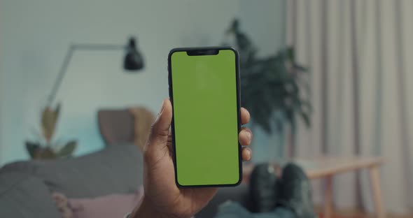 Close Up of Mobile with Green Mock Up Screen in Male Hands
