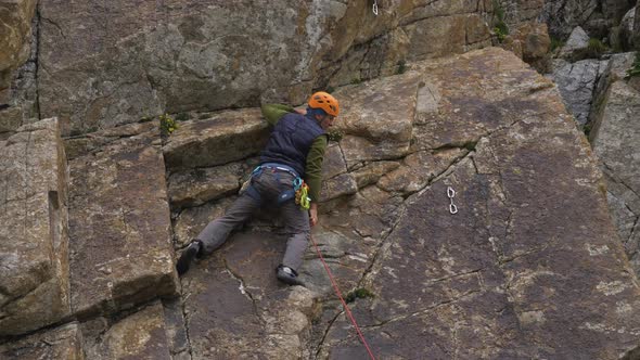 Rock Climbing. Man Puts the Rope in Quickdraw