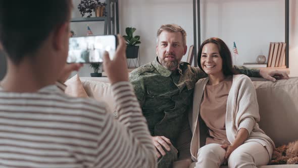 Boy Taking Photo of Father and Mother alt