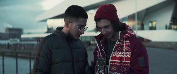 Two men looking at results of a photoshoot on vintage camera screens