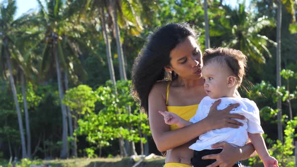 Young Asian Mother Having Tender Moment with Little Son Outdoor