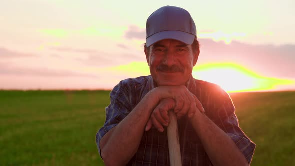 Glad Latin American Farmer with Cap Looking Away and Returns Facing at the Camera