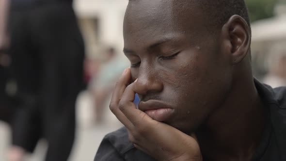 Pensive american african young man in the street- close up